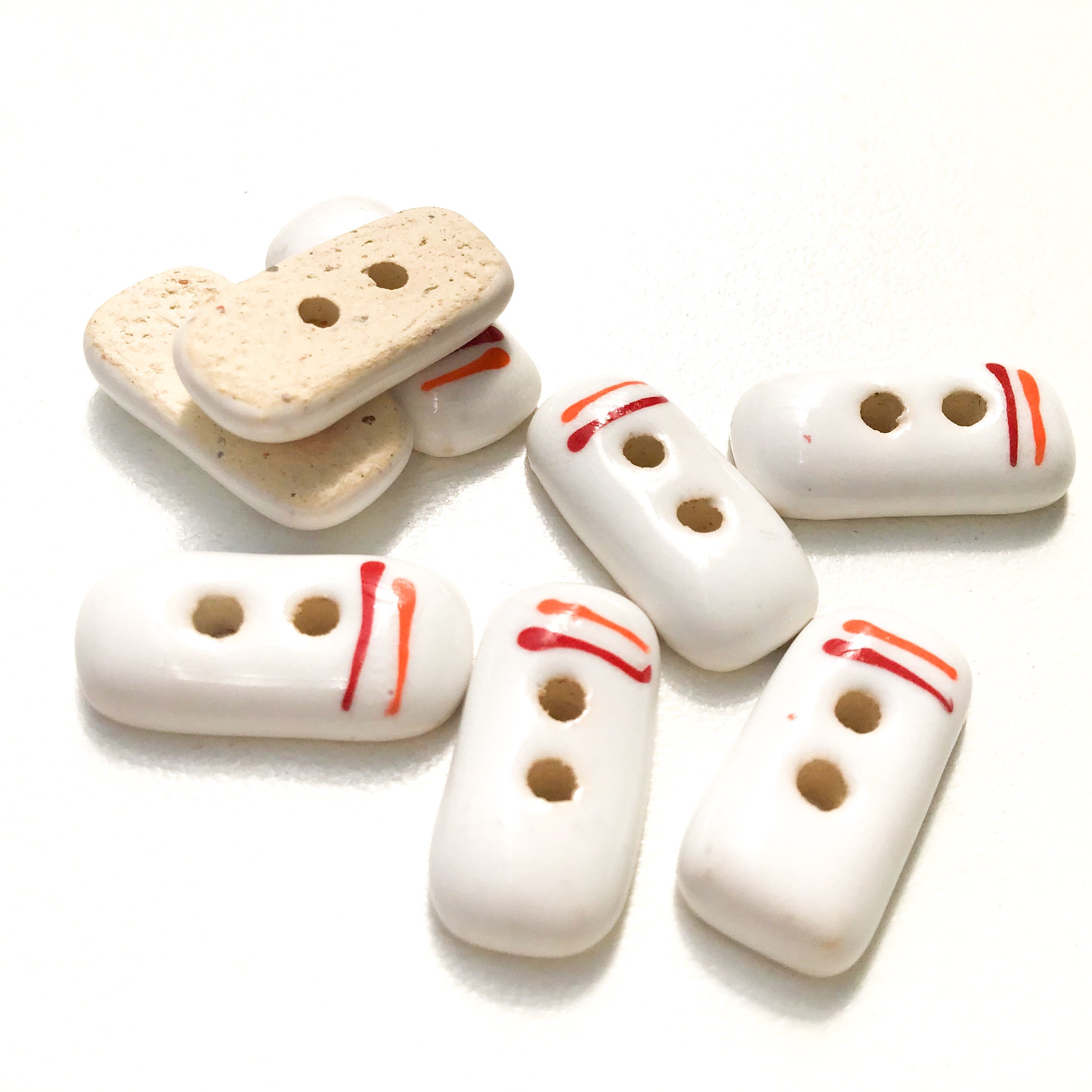 order-your-favorite-rectangular-white-ceramic-buttons-with-orange-red-lines-white-clay-buttons-3-8-x-3-4-8-pack-discount_2.jpg